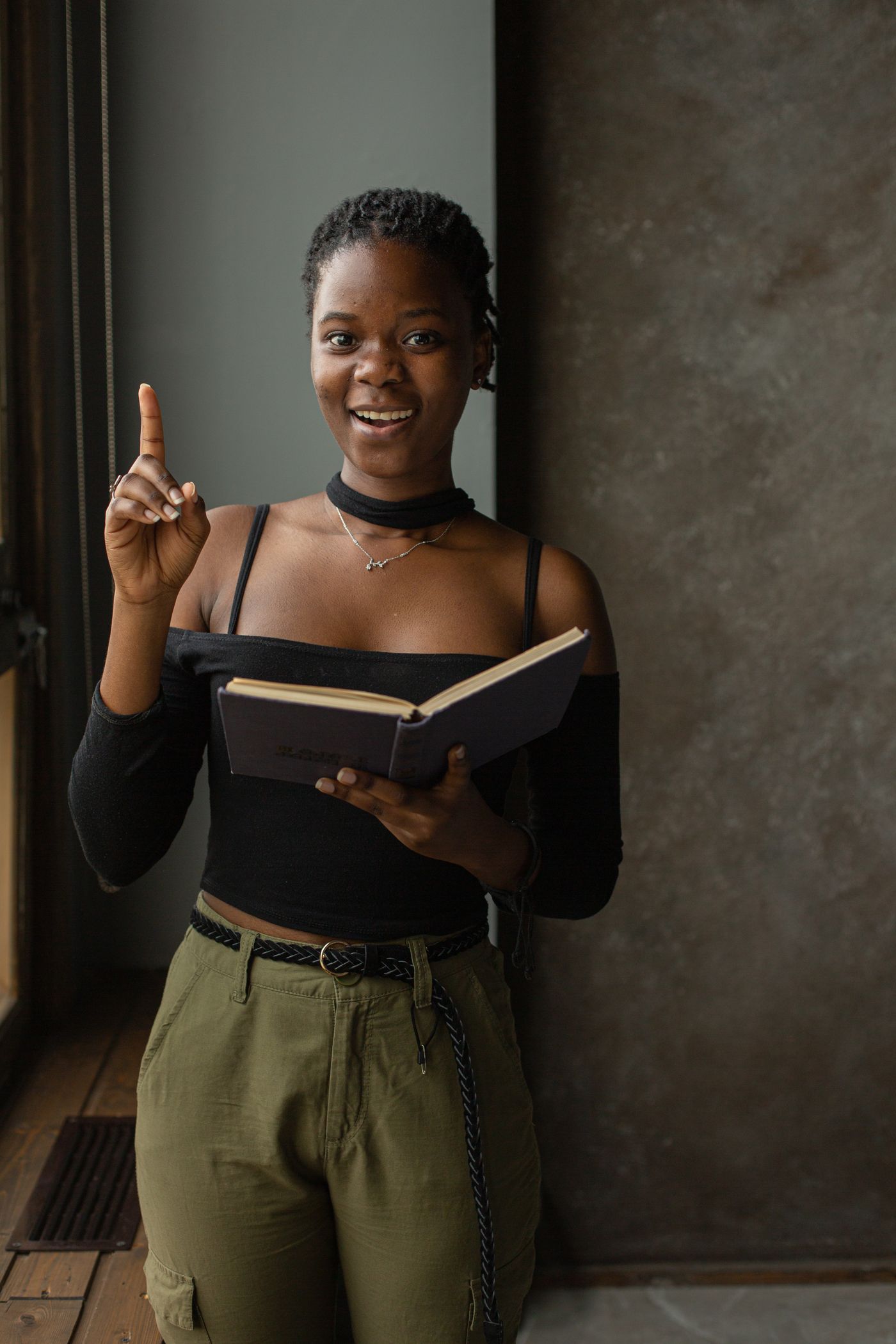 A woman smiling while holding an open book